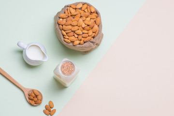 Almonds and milk bottle on light background. Almond nuts in spoon.