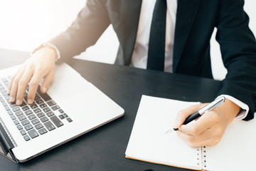 Side view shot of a man's hands using smart phone in interior, rear view of business man hands busy using cell phone at office desk,Business man using laptop computer,Business man working at office 