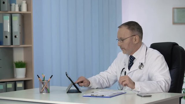 Doctor keeping patients medical record in hospital database, computerization