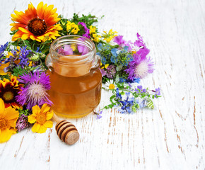 Glass with honey and wild flowers
