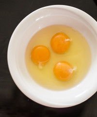 Eggs in white bowl close up top view