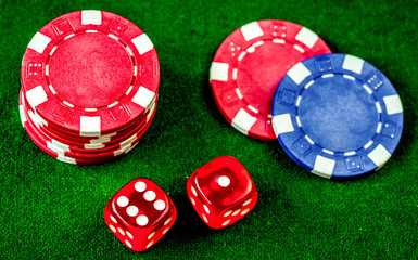 poker chips and dice on green background top view