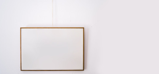 a white painting frame hanging from a white wall