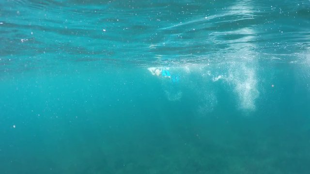 swimmer in flippers dives into the sea, raw, 4K