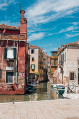 View on a venetian canal with ancient buildings and bridge in Venice