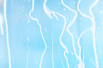 Blauer Hintergrund mit Wassertropfen auf Scheibe