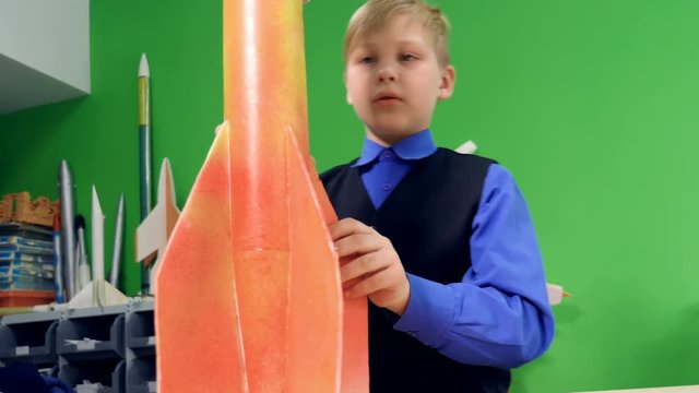 A kid is making a space rocket model at school