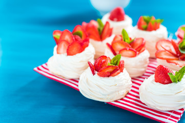 A small meringue Pavlova dessert with some strawberry slices