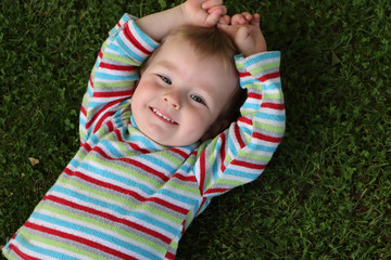 boy laying in the grass in a backyard