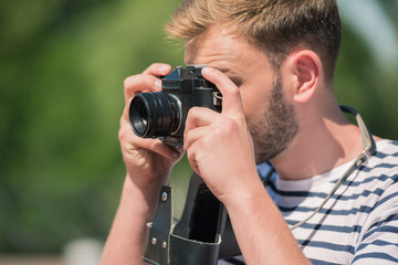 Fototapeta na wymiar bearded male photographer holding camera and taking photos