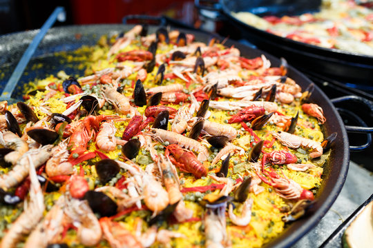 Large skillet with paella, yellow rice, mussels and seafood