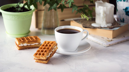 Cup of coffee and Belgian waffles with cream for breakfast