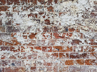 Brick wall covered in splashes of white paint and cement