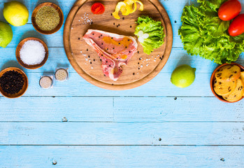Pork steak homemade cooking with spices leaves lettuce on wooden cutting board, and a dish,