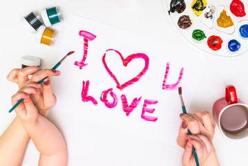 Child's hands painting a heart