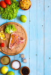 Pork steak homemade cooking with spices leaves lettuce on wooden cutting board, and a dish,