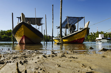 traditional malaysian fisherman boat moored near the riverbank over blue sky background