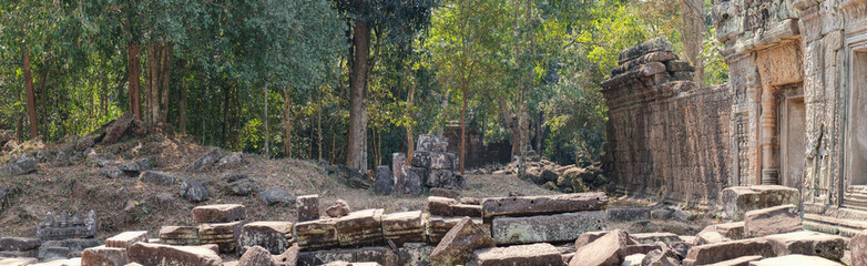 Fototapeta na wymiar The ancient ruins of the Preah Khan Temple in Siem Reap, Cambodia. View from a window on piles of stones and temple walls. Ancient Khmer architecture, famous Cambodian landmark, World Heritage