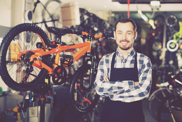 Obraz na płótnie Canvas Mechanic in bicycles store workshop