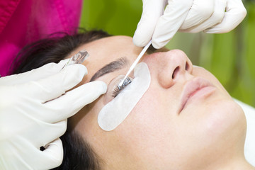 Woman on the procedure for eyelash extensions, eyelashes lamination 