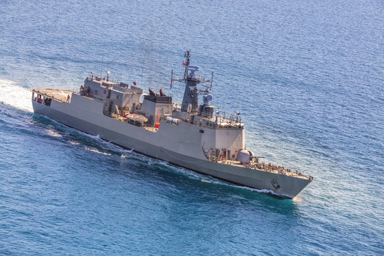 Grey modern warship sailing in the sea