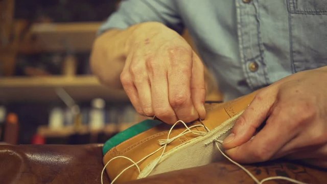 Close up of a cobbler man repairing a shoe at his workshop