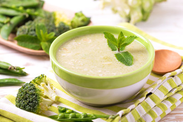 Obraz na płótnie Canvas Broccoli and green peas puree soup decorated with mint