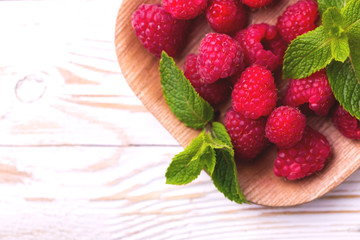 Fresh organic ripe raspberry with mint leaves in tray © dzevoniia