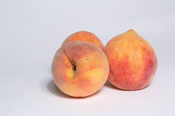 three ripe peaches isolated on white