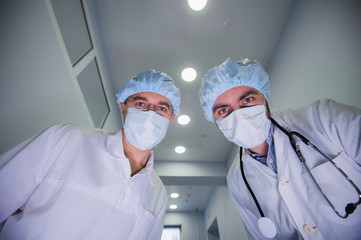 Surgeons standing above of the patient before surgery