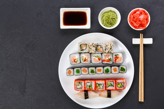 Set of sushi and rolls on gray background, top view