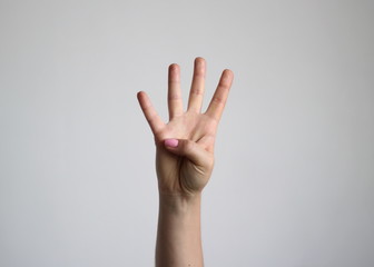 Young woman's hand shows four finger. Gesture.