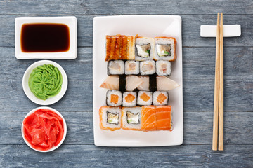 Set of sushi, maki and rolls on blue wooden background