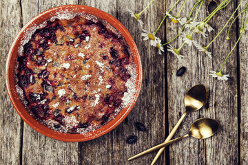 Honeysuckle clafoutis - traditional french berries pie, dessert on rustic wooden table. Selective focus. Toned image 