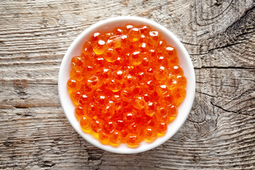 Bowl of red caviar on wood, from above