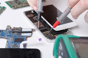 Repairing smartphone with multimeter close up