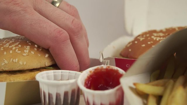 Male hand grabbing a fast food burger