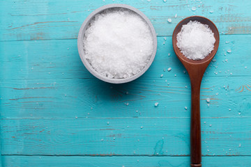 sea salt in bowl and in spoon on wooden background