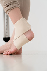 サポーターを巻いた女性、松葉杖