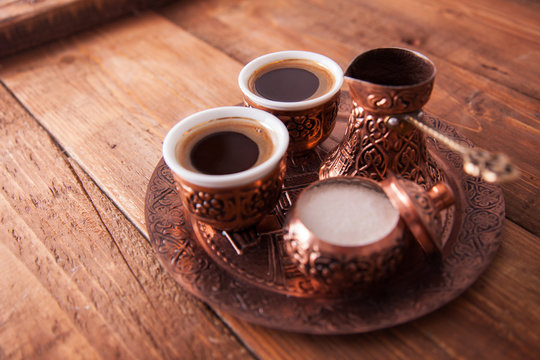 Antique bronze pitcher and coffee cup set with dates in a tray isolated on a white background,Turkish coffee set on wooden background.