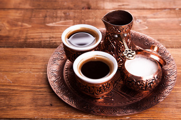 Antique bronze pitcher and coffee cup set with dates in a tray isolated on a white...
