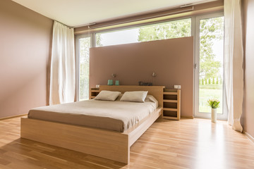 Fototapeta na wymiar Big bed with beige duvet
