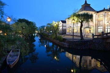 夕暮れの倉敷美観地区の倉敷館と川に浮かぶ川舟