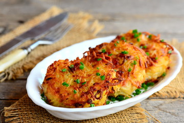 Crispy potatoes ham cutlets. Fried potato cutlets with ham on a white plate and an old wooden background. Rustic style. Closeup