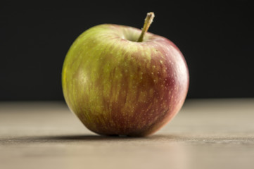 Close up shot of a red apple on wooden table