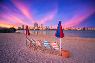 Deck chairs on a beach overlooking Perth City, Western Australia - obrazy, fototapety, plakaty