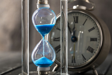 Time is passing. Blue hourglass close up