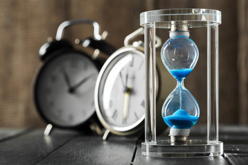 Time is passing. Blue hourglass close up