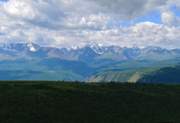 Fototapeta premium View of North-Chuysky ridge in Altai mountains. Background of big white clouds. Aktash, Altay Region, Siberia, Russia.