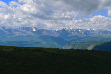 Landscape of North-Chuysky ridge in Altai mountains. Background of big white clouds. Aktash, Altay Region, Siberia, Russia.